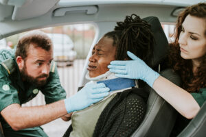 Auto Accident Attorney Beech Grove Indianapolis Indiana; Paramedic placing a cervical collar to an injured woman from car accident